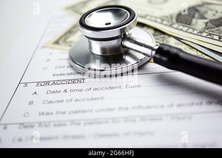 Assicurazione malattia infortunio modulo di reclamo con lo stetoscopio e il dollaro USA banconote, concetto medico. Foto Stock