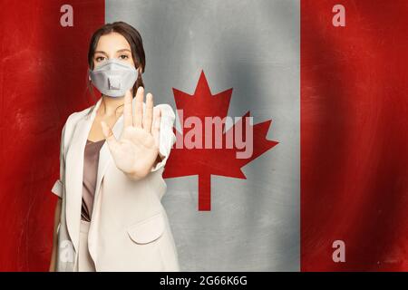 Donna in anti virus covid-19 maschera di protezione su sfondo bandiera Canada Foto Stock