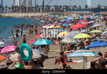 Bagnanti visto prendere il sole alla spiaggia di Malagueta durante una calda giornata estiva a Malaga.centinaia di spagnoli hanno riempito le spiagge approfittando del bel tempo per prendere il sole o bagnarsi in spiaggia. L'Agenzia Meteorologica Spagnola ha attivato l'allarme arancione in città per le alte temperature che saliranno più di 39º gradi. Foto Stock