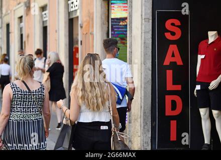 Roma, Italia. 3 luglio 2021. Il 3 luglio 2021, i clienti passano davanti a un negozio con un cartello di sconto durante la stagione estiva di vendita a Roma, Italia. La stagione delle vendite estive 2021 è iniziata sabato nella maggior parte delle regioni d'Italia. Credit: Jin Mamengni/Xinhua/Alamy Live News Foto Stock