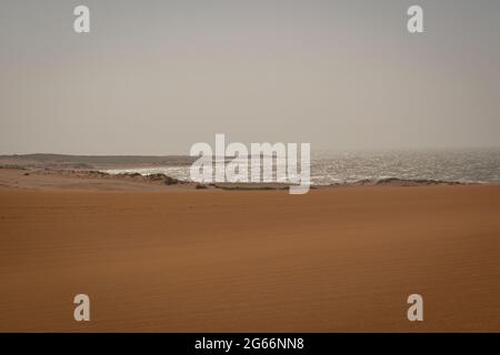 White Spume conosciuto come Mare, Oceano o schiuma da spiaggia creato dall'agitazione di acqua di mare vicino alle dune di Taroa con un giorno nuvoloso sfondo Foto Stock