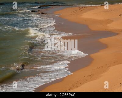 White Spume conosciuto come Sea, Ocean o Beach Foam creato dall'agitazione di acqua di mare Foto Stock