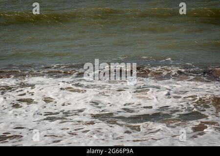 White Spume conosciuto come Sea, Ocean o Beach Foam creato dall'agitazione di acqua di mare Foto Stock