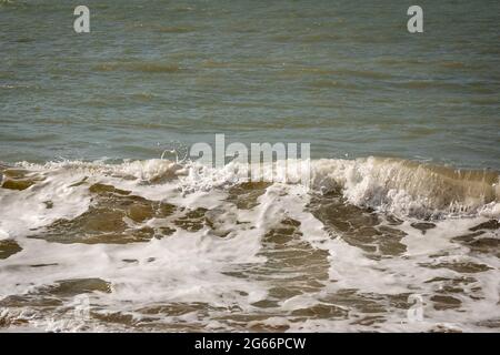 White Spume conosciuto come Sea, Ocean o Beach Foam creato dall'agitazione di acqua di mare Foto Stock