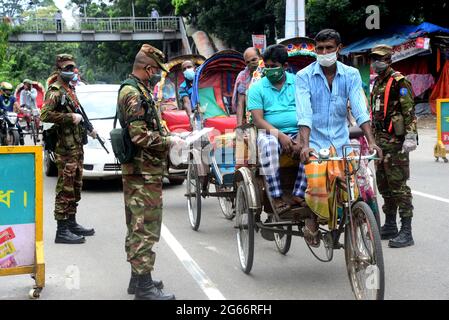 Il personale dell'esercito del Bangladesh pattuglia per strada in un punto di controllo durante il rigido blocco di Coronavirus Covid-19 a Dhaka, Bangladesh, il 3 luglio 2021. Le autorità del Bangladesh hanno imposto il blocco totale a livello nazionale per una settimana tra le crescenti infezioni da coronavirus e i decessi correlati al coronavirus nel paese. Foto Stock