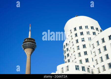 Edificio bianco progettato dal famoso architetto statunitense Frank O. Gehry a 'Neuer Zollhof', Medienhafen, e la torre del Reno di Düsseldorf. Foto Stock