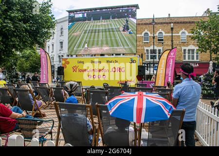 WIMBLEDON LONDRA 3 luglio 2021. Gli appassionati di tennis guardano la partita dal vivo tra il tennista britannico Emma Raducanu e Sorana Cirstea su un grande schermo nel centro di Wimbledon. Le partite dal vivo vengono mostrate ogni giorno durante i Campionati di Wimbledon in uno spazio socialmente distanziato. Credit amer Ghazzal/Alamy Live News Foto Stock