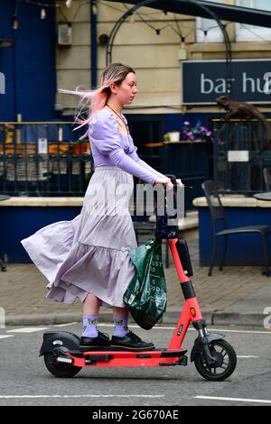 Bristol, Regno Unito. 03 luglio 2021. Nelle strade della città di Bristol, gli e-Scoooters sono visti dai cavalieri che si godono il pomeriggio. Le loro sono linee guida per le aree locali e gli operatori di noleggio -GOV.UK Scooter elettrici non possono essere guidati sui marciapiedi, gli utenti possono noleggiare scooter di prova da un'app sul telefono cellulare, l'utente deve essere in possesso di una patente di guida e rispettare la legge come stabilito. Gli scooter e devono essere utilizzati solo da una persona, non da 2 o tre persone. Credito immagine: Robert Timoney/Alamy Live News Foto Stock