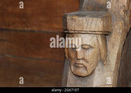 Dettaglio della testa scolpita sulla stalla del coro risalente al XVI secolo a St Beunos, Clynnog Fawr, Galles Foto Stock