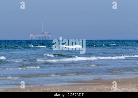 Ameland, Olanda aprile 20,2021-NAM, piattaforma offshore con spiaggia, sabbia e surf. Estrazione di gas naturale nella regione di Wadden-Mare del Nord Foto Stock