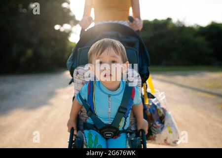 Un bambino che viene spinto in un passeggino Foto Stock