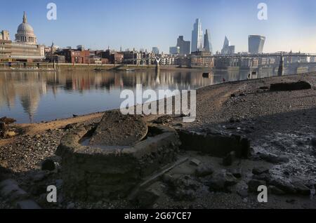 Londra, Regno Unito. 27 Feb 2021. Lo skyline della città di Londra visto dal litorale del Tamigi con la bassa marea. Le rive del fiume crescono gradualmente quando il Tamigi raggiunge la bassa marea. Le spiagge ben note ai fangatori e ai beachcomber e visibili solo per un paio d'ore al giorno danno londinesi, oltre un anno in blocco, in qualche luogo diverso da camminare ed esplorare. Credit: Martin Pope/SOPA Images/ZUMA Wire/Alamy Live News Foto Stock