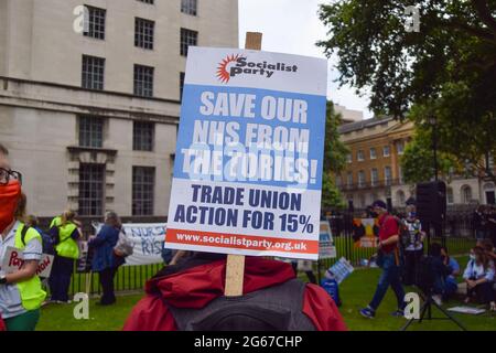 Londra, Regno Unito. 3 luglio 2021. Un protestore tiene una targhetta 'Save our NHS from the Tories' fuori Downing Street. I lavoratori e i sostenitori del NHS (National Health Service) hanno marciato attraverso il centro di Londra chiedendo un equo aumento salariale per il personale del NHS e in generale il sostegno del NHS. (Credit: Vuk Valcic / Alamy Live News) Foto Stock