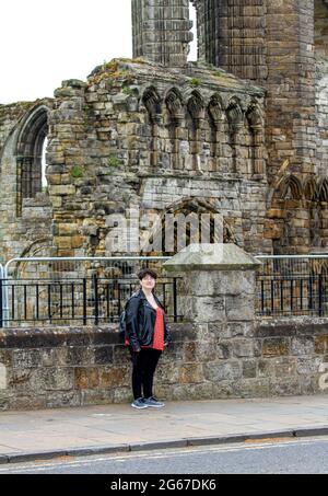 St Andrews, Fife, Scozia, Regno Unito. 3 luglio 2021. Regno Unito tempo: Una giornata fredda nebbiosa attraverso la Scozia nord-orientale con temperature che raggiungono i 15°C. Un turista americano prende la giornata per essere fotografato mentre si visita le rovine della cattedrale di `s del 1400 a St Andrews. Credit: Dundee Photographics/Alamy Live News Foto Stock