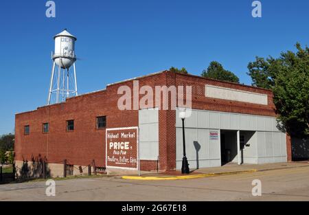 Una vecchia torre d'acqua sorge sopra un edificio commerciale in mattoni su Main Street nella città di Depew, Oklahoma, sulla Route 66. Foto Stock