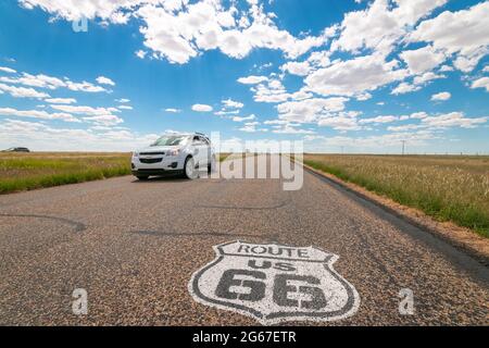 Scudo verniciato sulla superficie stradale della Route 66 Texas con SUV Chevrolet bianco Foto Stock