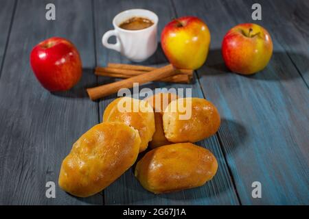 Torte fresche con mele, cannella e caffè su un tavolo di legno blu Foto Stock