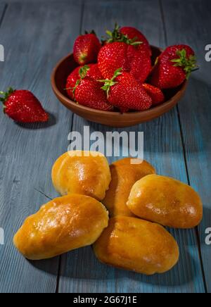 Torte fresche e fragole su un tavolo di legno blu Foto Stock