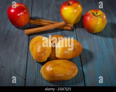 Torte fresche con mele e cannella su un tavolo di legno blu Foto Stock