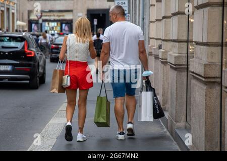 Milano, Italia, 3 luglio 2021 - primo giorno di vendite estive - passeggiata in coppia con borse in via Montenapoleone Credit: Christian Santi/Alamy Live News Foto Stock