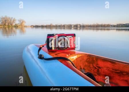 Fort Collins, CO, Stati Uniti d'America - 6 maggio 2021: Compatta, impermeabile Olympus Stylus Tough TG-5 fotocamera su un ponte posteriore di un stand up paddleboard di Mistral, primi s. Foto Stock