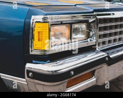 Faro auto. Faro del veicolo costituito da blocchi giocattolo gialli. Sintonizzazione divertente della vecchia auto Foto Stock