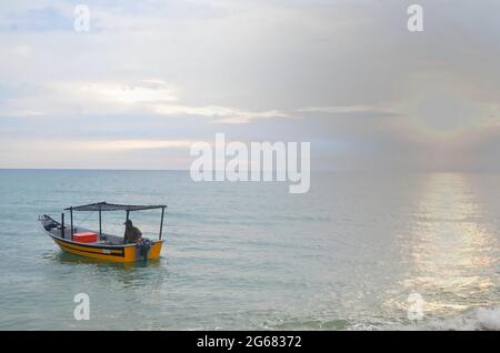 Terengganu, Malesia: 13 settembre 2014 - un pescatore sulla sua piccola barca che esce al mare. Punti di messa a fuoco selettivi. Sfondo sfocato Foto Stock