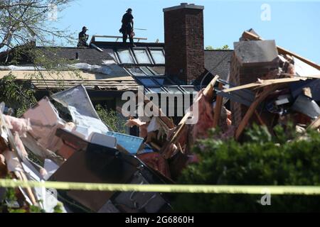 I tetti lavorano su un tetto come rami di alberi rotti, detriti dispersi e case gravemente danneggiate sono visti blocco dopo blocco vicino Ranchview Drive e Princeton Circle il 22 giugno 2021, dopo il tornado di Naperville, Ill. (Foto di Antonio Perez/Chicago Tribune/TNS/Sipa USA) Credit: Sipa USA/Alamy Live News Foto Stock