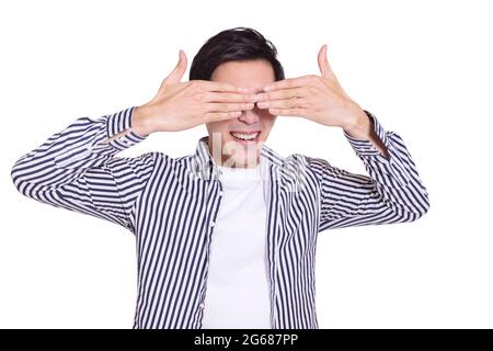 Giovane uomo coprendo gli occhi con le mani e ridendo.isolato su sfondo bianco. Foto Stock