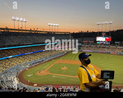 Fornitore che prende il pagamento con un piccolo dispositivo elettronico durante la partita di baseball notturna al Dodger Stadium di Los Angeles, California Foto Stock