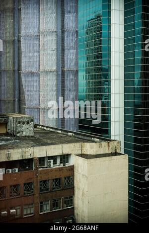 Vecchio e nuovo: La cima di un vecchio edificio e un'alta torre commerciale, con un altro in costruzione, Causeway Bay, Hong Kong Island Foto Stock