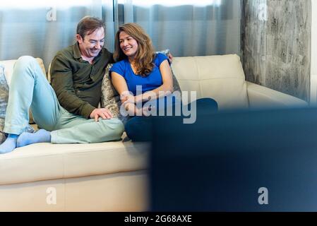 Uomo e donna maturi sul divano guardando un film. Foto Stock