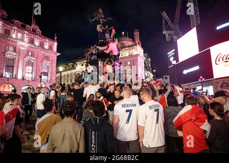 Londra, Regno Unito. 03 luglio 2021. Gli appassionati di calcio si riuniscono e salgono fino alla fontana Eros per celebrare la vittoria della squadra inglese.centinaia di tifosi inglesi si sono riuniti ancora una volta nel centro di Londra per celebrare una vittoria 4:0 sull'Ucraina nella UEFA Euro 2020 che si svolge oggi in Italia. La squadra inglese entrerà ora nella semifinale e si schiererà contro la Danimarca a Wembley la prossima settimana. Credit: SOPA Images Limited/Alamy Live News Foto Stock