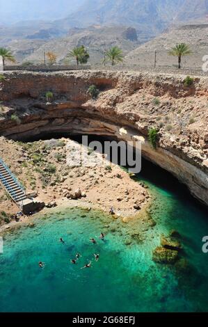 OMAN. LA COSTA. LA GROTTA COLLAPSED DI BIMMAH È UN LUOGO UNICO PER FARE UNA NUOTATA IN ACQUA SALATA E PURA. Foto Stock