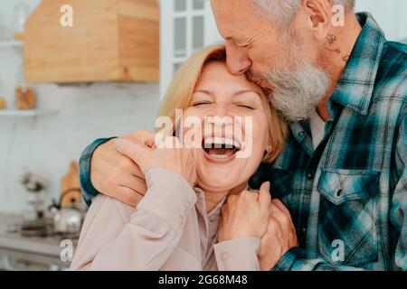 Marito e moglie in pensione si abbracciano a casa Foto Stock