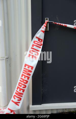 le cassette di emergenza della polizia impediscono l'accesso del pubblico in una scena di sospetto crimine ancora sotto inchiesta Foto Stock