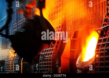 steelworker al lavoro che versa metallo in officina Foto Stock