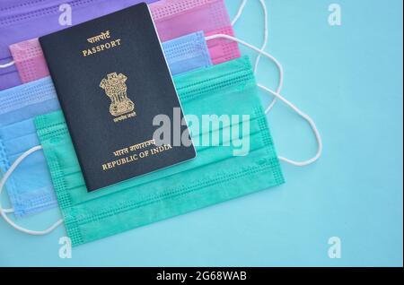 Mandi, Himachal Pradesh, India - 04 24 2021: Concetto di viaggio durante la pandemia di Coronavirus (crisi Covid19), vista ad alto angolo del passaporto indiano su maschera medica multicolore (maschera protettiva) Foto Stock