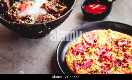 Frittata di frittata di uova di patate pancetta paprika prezzemolo piselli verdi formaggio di cipolla per cibo delizioso. Foto Stock
