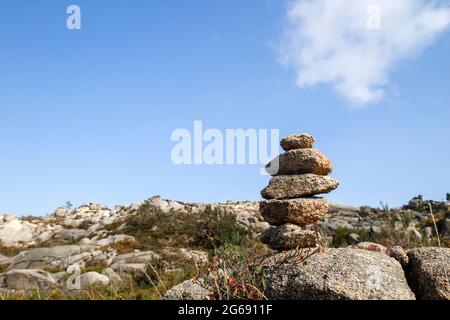 Cairn o marcatore di pietra in sentiero di montagna Foto Stock