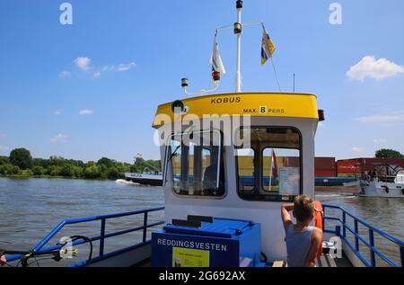 Blitterswijck, Paesi Bassi - 1 luglio. 2021: Vista sulla cabina del conducente di traghetto per piccoli passeggeri e biciclette (voet- en fietsveer) sul fiume maas, container sh Foto Stock