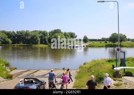 Broekhuizen, Paesi Bassi - 1 luglio. 2021: Vista sulle persone in attesa del passeggero, auto e traghetto in bicicletta sul fiume maas ad arcen in estate Foto Stock