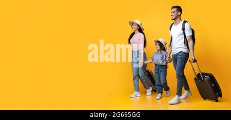 Felice famiglia mediorientale allegra di tre con valigie in vacanza Foto Stock