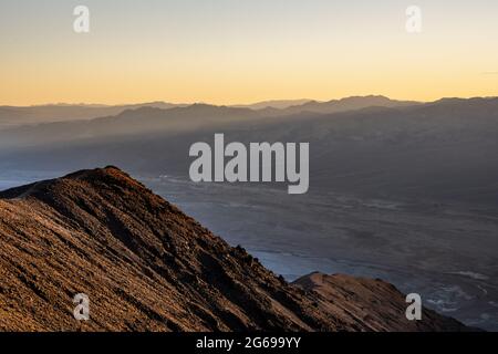 Alberi di Sunlight si rompano sopra il crinale come visto da Dantes View nella Valle della morte Foto Stock