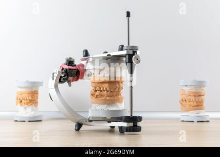 Articolare dentale con modello di protesi mascellare dentale sul tavolo in laboratorio dentale Foto Stock