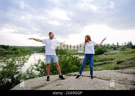 Destinazioni per luna di miele economiche, fuga romantica, viaggio in coppia da solo. Coppia innamorata, sposi novelli in t-shirt bianca che si divertono sulla natura Foto Stock