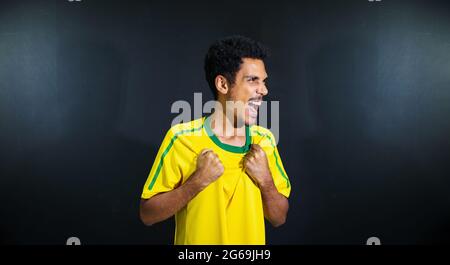 Olimpiadi felice uomo nero ventilatore in uniforme isolato su sfondo nero. Foto Stock