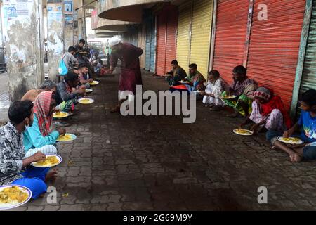 Dhaka, Bangladesh. 04 luglio 2021. I volontari distribuiscono cibo ai senzatetto durante il blocco imposto per contenere la diffusione del coronavirus Covid-19 nell'area del terminal degli autobus di Gastali a Dhaka il 4 luglio 2021. Credit: Mamunur Rashid/Alamy Live News Foto Stock