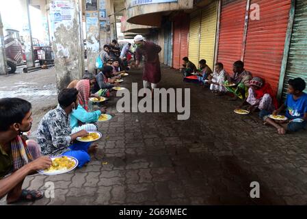 Dhaka, Bangladesh. 04 luglio 2021. I volontari distribuiscono cibo ai senzatetto durante il blocco imposto per contenere la diffusione del coronavirus Covid-19 nell'area del terminal degli autobus di Gastali a Dhaka il 4 luglio 2021. Credit: Mamunur Rashid/Alamy Live News Foto Stock