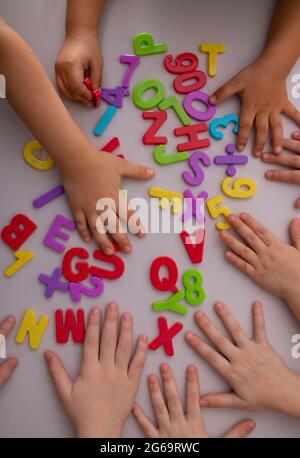 Bambini con lettere e numeri colorati in plastica Foto Stock